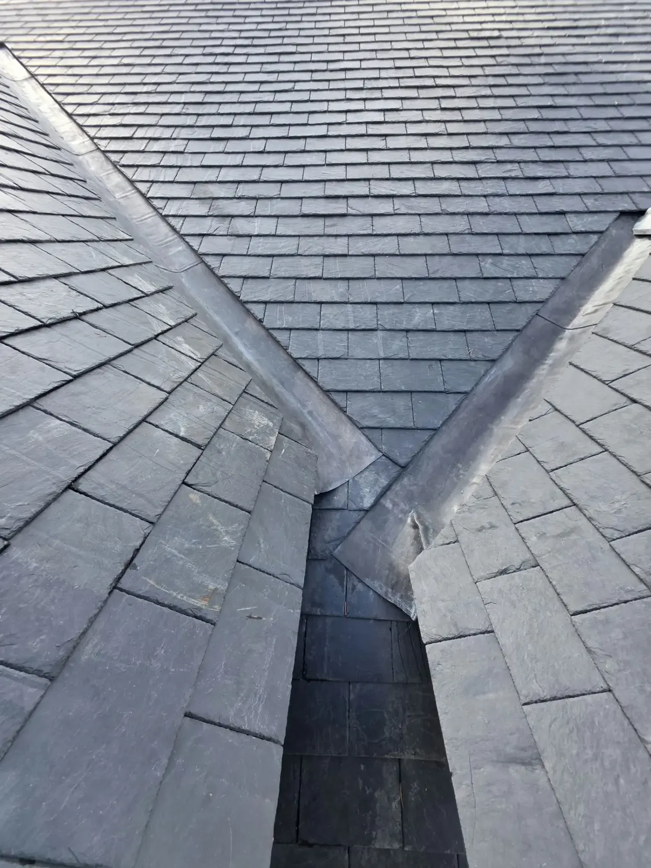 Lead-lined valleys meeting between new natural slate roof slopes